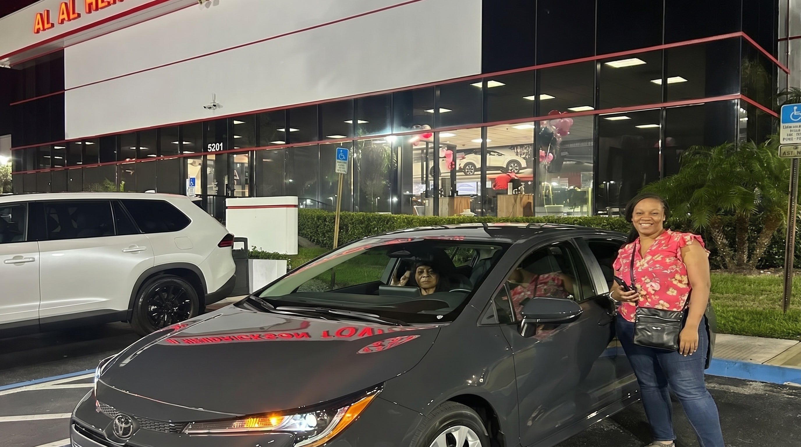 Stanley customer with a new Toyota outside the dealership at night