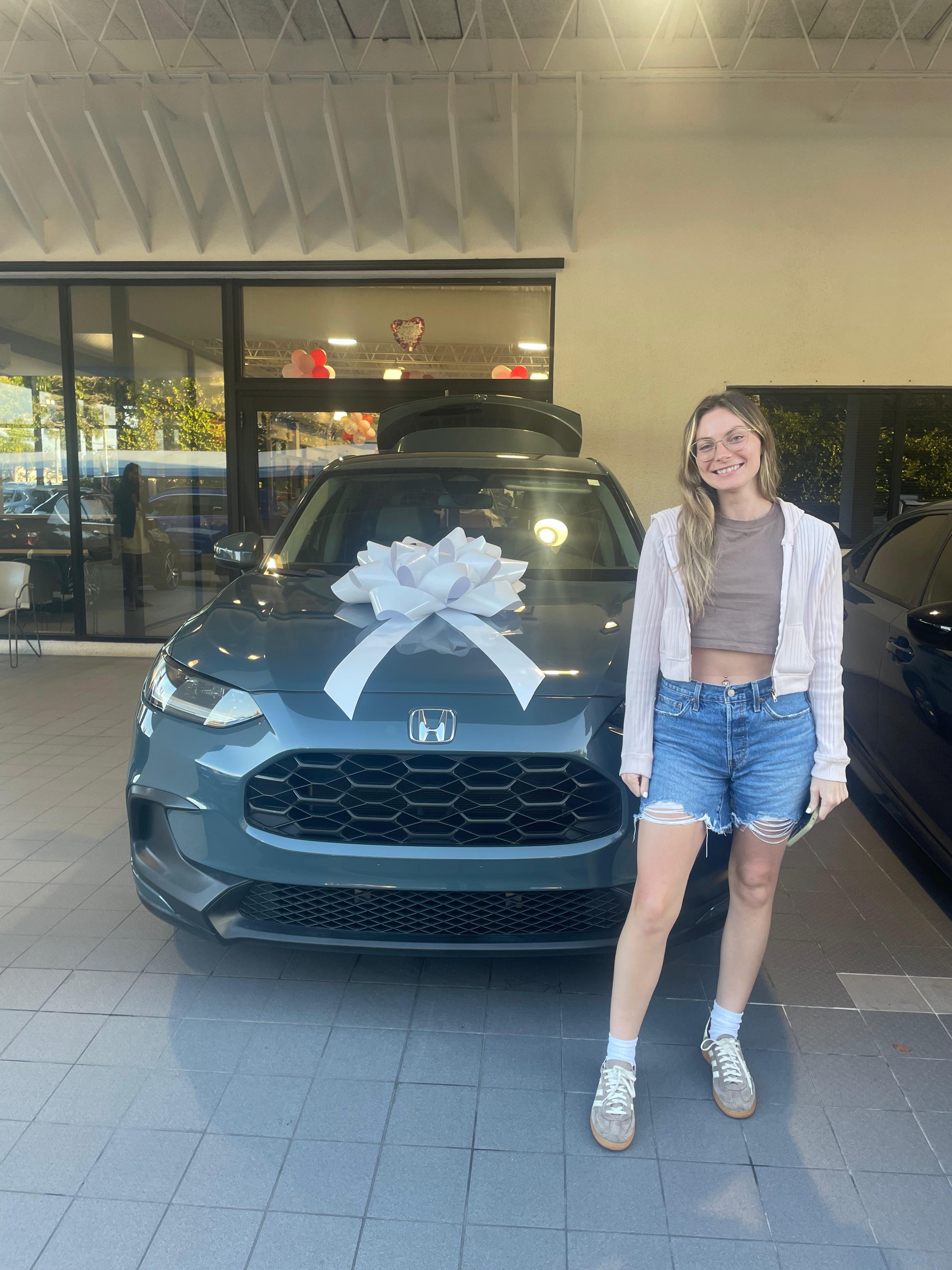 Happy customer standing near a newly purchased vehicle